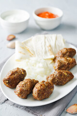 Minced meat sausage with onion, sour cream, pita and red bell pepper relish