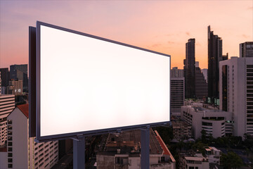 Blank white road billboard with Bangkok cityscape background at night time. Street advertising poster, mock up, 3D rendering. Side view. The concept of marketing communication to sell idea.