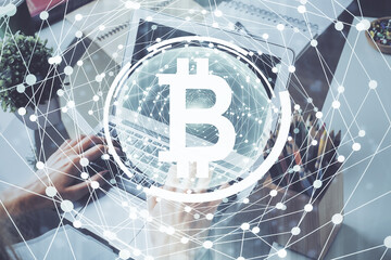 Crypto currency theme hologram with businessman working on computer on background. Concept of blockchain. Double exposure.