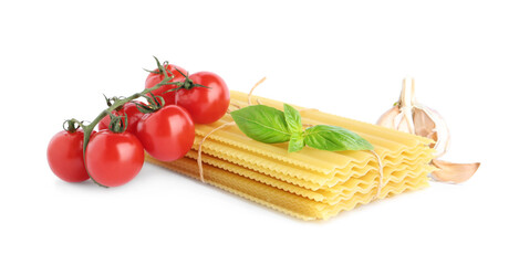 Uncooked lasagna sheets with cherry tomatoes, garlic and basil isolated on white
