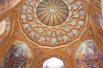 Beautiful Islamic patterns of Uzbekistan,  Geometric and floral background, blue and golden ceramic tiles on the ceiling in Sher-Dor Madrasah at Registan square