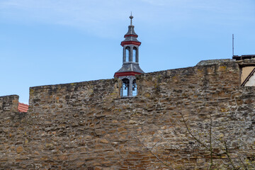 Part of the historic city wall with bell tower in the background in Meisenheim © Reiner
