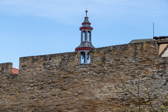 Part of the historic city wall with bell tower in the background in Meisenheim