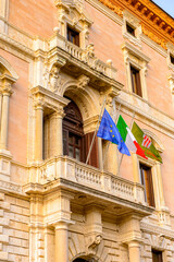 It's Italian and European Union flags on a balcony of the City Hall of Perugia, Umbria, Italy