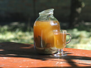 bread kvass with malt and mint in a glass jar illuminated by the sun