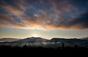 Himmlische Kunst kontrastreich und farbig, berge im Hintergrund mit Sonnenaufgang, im Thal etwas Dunst
