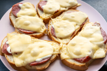Homemade hot sandwiches with sausage and melted cheese for breakfast in the morning. Close-up. 