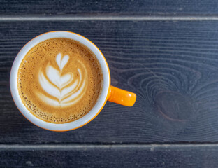 Italian cappuccino coffee cup top view on dark wood table background, space for text