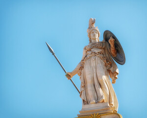 Athena marble statue with helmet, spear and shield under clear blue sky, Athens Greece