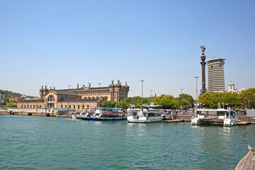 Obraz premium View across the harbour towards the city including the Columbus Monument, Aduana Building and the old customs building at Port Vell, Barcelona, Spain.