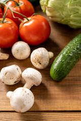 Tomatoes, cucumber, cabbage and mushrooms champignons on a brown wooden table. Vegetables - vegetarian food. Agricultural products. Top-Side view. 