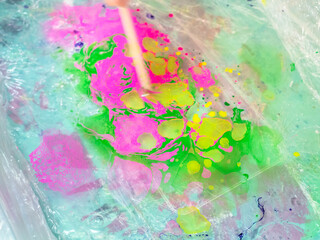 workshop of Ebru paper marbling - stick mixes paints on surface of liquid in plastic basin for printmaking