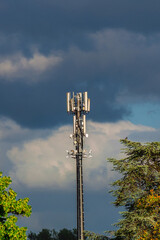 Electromagnetic radiation and environment issue. Telecommunication tower with 5G and 4G antennas among trees