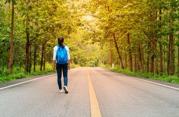 Fototapeta premium young woman walking on the road in a forest
