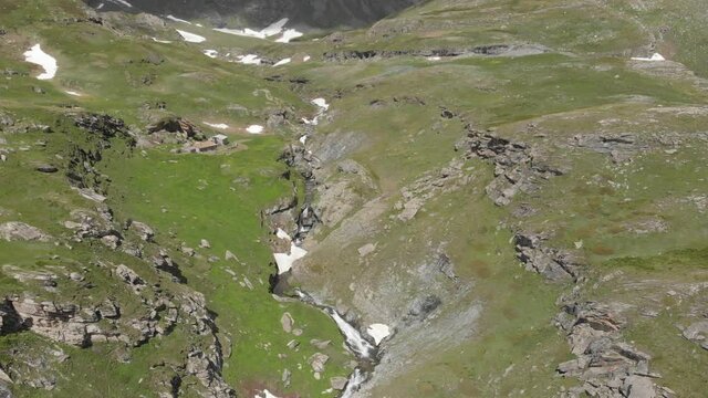 Aerial: drone flying over scenic high waterfall, mountain stream falling from tall rocky cliff on the italian Alps. Pis waterfall near Torino, Piedmont, Italy. Native d-log color profile
