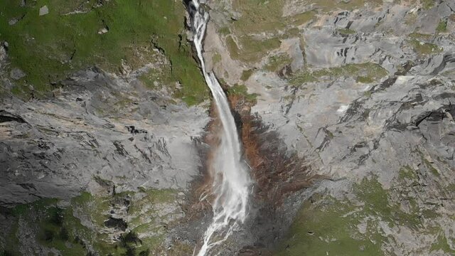Aerial slow motion: drone flying over scenic high waterfall, mountain stream falling from tall rocky cliff on the italian Alps. Pis waterfall near Torino, Piedmont, Italy