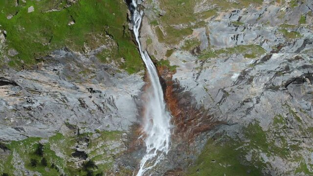 Aerial: drone flying over scenic high waterfall lush green valley and mountain stream on the italian Alps. Tourism destination hiking outdoors activity. Pis waterfall near Torino, Piedmont, Italy