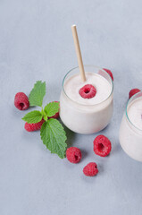 Glass of raspberry milkshake on wooden background