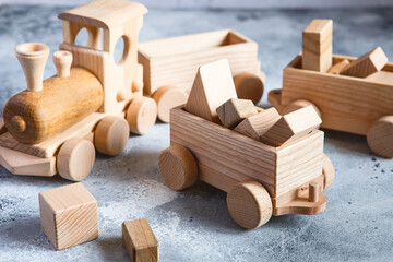 Fototapeta na wymiar Children's wooden toys. Children wooden train with wagons. Natural wood construction set. Educational equipment