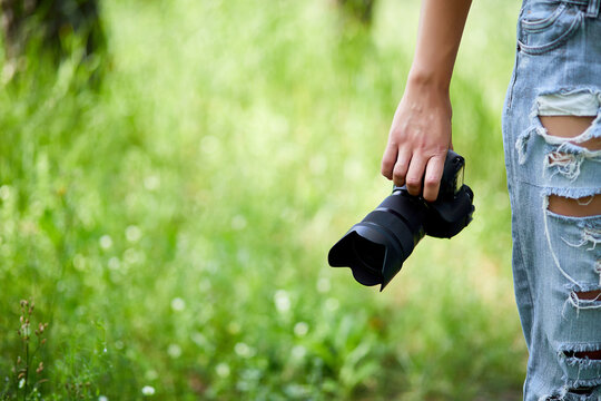 Woman photographer with a photo camera in hand outdoor
