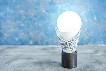 luminous led lamp in an electric socket in a 100 dollar bill. electrical energy conservation concept