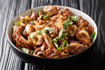 Armenian cuisine recipe chicken liver, heart and stomachs with onions, tomatoes and spices close-up in a bowl on the table. horizontal