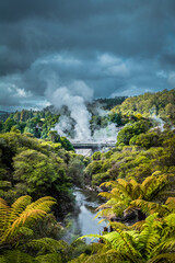 Fototapeta na wymiar Hot steam from geysers rising over mountains near Rotorua, New Zealand.