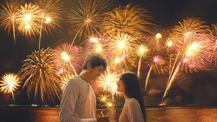 Happy new year 2021 celebration. Young couple new year fireworks countdown. Romantic couple under fireworks on sky.