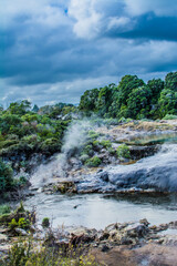 Terraces geothermal pools over mountain stream.