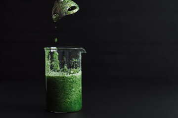 One Green Smoothie Cocktail is Standing on the Black Table