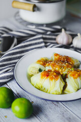 Stuffed cabbage rolls on white plate.