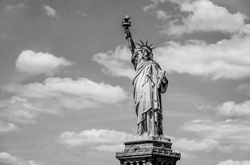 USA: The outdoor Statue of Liberty on a background of blue sky with white clouds on Liberty Island...