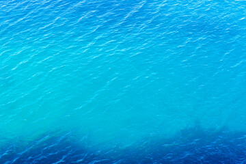 Fototapeta na wymiar Ripple of blue sea water. Textured sea water background. Top view.