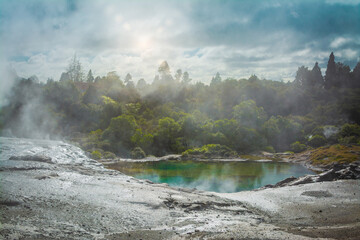 Moody landscape with steam rising pool in a geothermal zone in the mountains