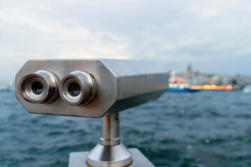 Tourist telescope against blurred sea background. Binoculars for sightseeing. 