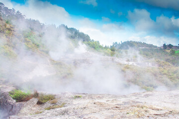 Smoking ground - steam rising over geothermal area in mountains near Rotorua