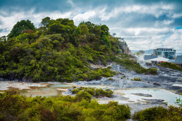 Surreal gloomy landscape with steam rising over hot mud pools in the mountains