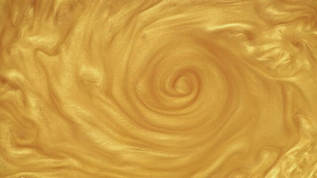 Gold ink in water. Metamorphosed formations of gold dust, shiny sand