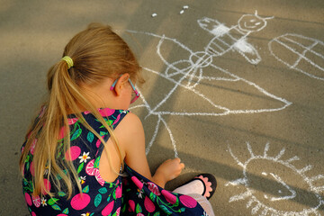 Dziewczynka rysująca kredą na chodniku - obrazy, fototapety, plakaty