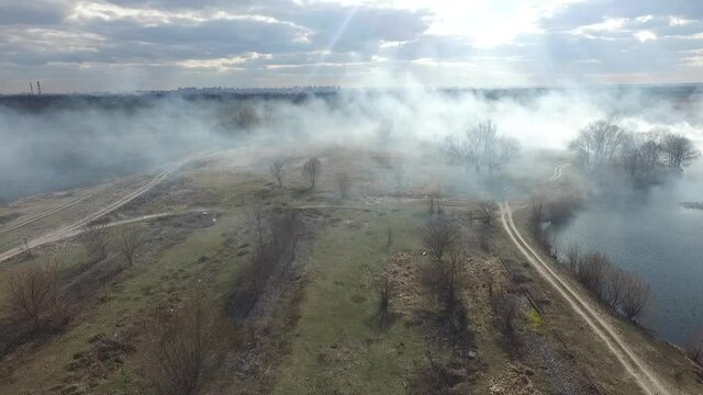 The smoke from the burning of dry grass (drone image).Local residents set fire to the grass specifically. Small animals are bending. Local features and habits. Near Kiev,Ukraine