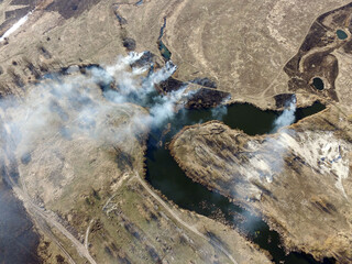 The smoke from the burning of dry grass (drone image).Local residents set fire to the grass specifically. Small animals are bending. Local features and habits.  Near Kiev,Ukraine