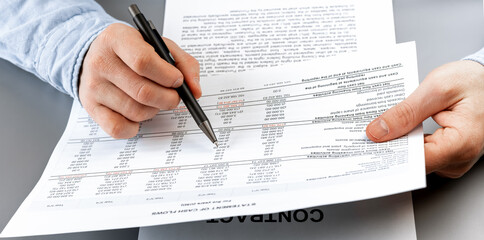 Obraz premium Cropped view of businessman works with financial papers at the table. Finance concept
