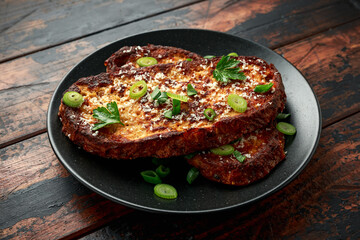 Parmesan cheese French Toast with spring onion on black plate