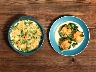 baked cutlets in spinach sauce with cheese on a wooden table in a baking dish and in a plate