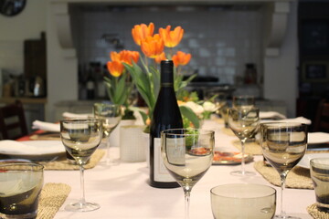 Holiday celebration luxury dinner with orange tulips and wine glasses