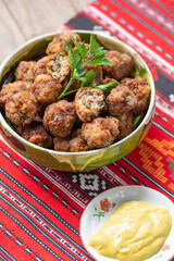 fried meat balls in clay bowl on traditional cloth