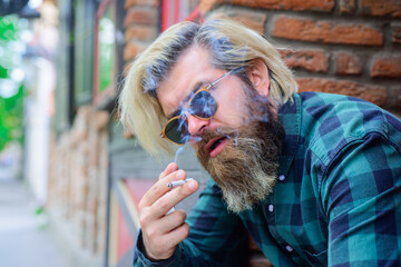 Cigarette smoke. Close up portrait of smoking man. Sensual bearded hipster with cigarette. Man smoke the cigarette. Sensual man smoking outdoor. Tobacco. Hipster with cigarette.