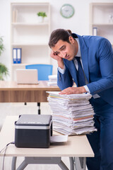 Obraz premium Young male employee making copies at copying machine