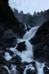 Latefossen Waterfall, unique waterfall epic powerful main silky flow vertical photo in dark light with long exposure. Twin waterfall in the Odda valley, Norway