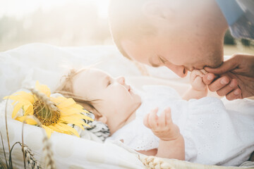 Cute baby girl laying in a cradle at the rye field. Happy young father enjoy time together at the nature. Father and little baby girl resting outdoors. togetherness, love, happiness concept.